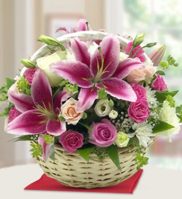 Round basket arrangement of 4 stems of pink lilies , 14 Pink Roses , 6 peach roses , 6 white roses and 2 stems of White chrysanthemums with lots of greens and gypsophillia Fragrant Blooms