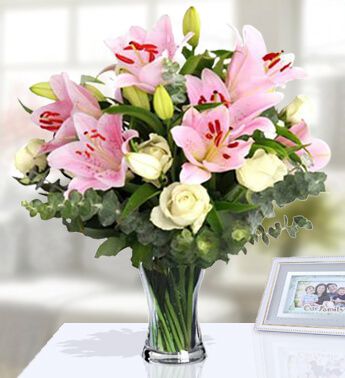 Glass vase with 10 Stem of White Roses and 4 Stem of Pink Lilies (Approx 12 Flowers) with greens Cheery Bouquet