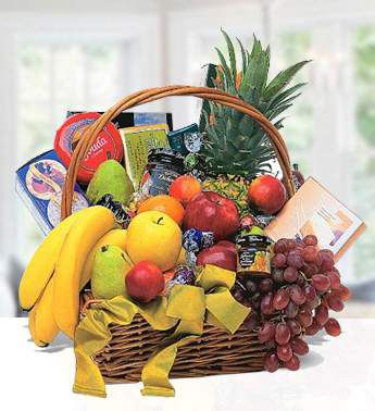 A large basket containing fresh pineapple, apples, pears, bananas and red grapes. Also a premium selection of biscuits, chocolates and crackers. Adorned with a large bright bow . Mega Basket